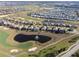 Aerial view of community homes with pond and golf course; beautiful place to live with many amenities at 760 Pebble Beach Dr, Davenport, FL 33896