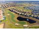 Aerial view of community homes next to the golf course and pond, perfect for golf enthusiasts with luxury living at 760 Pebble Beach Dr, Davenport, FL 33896