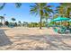 Beautiful pool area with sun loungers and tables under palm trees on a bright, sunny day at 760 Pebble Beach Dr, Davenport, FL 33896