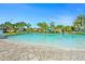 Large community pool and play area surrounded by palm trees under a bright blue sky at 760 Pebble Beach Dr, Davenport, FL 33896