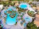 Aerial view of the community pool with splash pad, lazy river, plenty of seating, and lush landscaping at 760 Pebble Beach Dr, Davenport, FL 33896