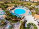 A bird's-eye view of the community pool features a large round swimming pool and lounge chairs with shade umbrellas at 760 Pebble Beach Dr, Davenport, FL 33896