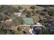 Aerial view of a tennis court and a basketball court surrounded by homes and lush greenery at 6143 Black Walnut Dr, Bartow, FL 33830