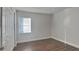 Simple bedroom with wood-look floors, neutral paint, closet, and a window with blinds at 854 4Th St, Winter Haven, FL 33881