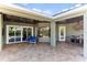 Comfortable covered patio with brick pavers, outdoor kitchen, ceiling fans, and view of the pool at 4079 Grandefield Cir, Mulberry, FL 33860