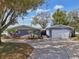 Charming one-story home featuring a two-car garage, driveway, mature trees, and attractive landscaping at 801 13Th Ne Ct, Winter Haven, FL 33881