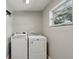 Bright laundry room featuring white washer, dryer and a window at 801 13Th Ne Ct, Winter Haven, FL 33881