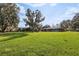 Expansive grassy backyard with trees and view of the house at 8309 W Lake Marion Rd, Haines City, FL 33844