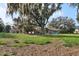 Large backyard featuring a large, moss-covered tree in a residential setting at 8309 W Lake Marion Rd, Haines City, FL 33844