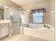 Bright bathroom featuring a large soaking tub, a glass shower, and neutral color palette at 417 Lake Butler Dr, Kissimmee, FL 34759