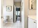 Bright bathroom with toilet, white tile floor, and doorway view into the bedroom at 417 Lake Butler Dr, Kissimmee, FL 34759