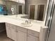 Bathroom featuring double sinks, white cabinetry, and a glass-enclosed shower at 417 Lake Butler Dr, Kissimmee, FL 34759