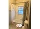 Clean white tiled bathtub and toilet with a window providing natural light at 417 Lake Butler Dr, Kissimmee, FL 34759