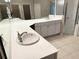 Bathroom featuring double sinks, white cabinetry, and a glass-enclosed shower at 417 Lake Butler Dr, Kissimmee, FL 34759