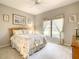 Cozy bedroom with a floral-patterned comforter, a ceiling fan, and a bright window with soft curtains at 417 Lake Butler Dr, Kissimmee, FL 34759