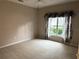 Spacious bedroom features neutral carpeting, ceiling fan, and a bright window with patterned curtains at 417 Lake Butler Dr, Kissimmee, FL 34759