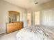 Bright bedroom boasts a wooden dresser with mirror and doorways to other rooms at 417 Lake Butler Dr, Kissimmee, FL 34759
