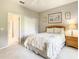 Comfortable bedroom featuring a closet, bedside table with lamp, and doorway leading to a bathroom at 417 Lake Butler Dr, Kissimmee, FL 34759