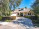Charming single-story home with a welcoming front porch, lush landscaping, and a brick-paved driveway at 417 Lake Butler Dr, Kissimmee, FL 34759