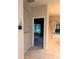 Hallway with tile flooring leading to bedroom, thermostat on wall, and view of outdoor landscape at 417 Lake Butler Dr, Kissimmee, FL 34759
