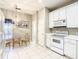 Well-lit kitchen with white appliances, tiled floors, and a cozy breakfast nook, creating a warm and inviting space at 417 Lake Butler Dr, Kissimmee, FL 34759