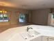 Open-concept living room with tile floors, chandelier, ceiling fan, and view of the lanai at 417 Lake Butler Dr, Kissimmee, FL 34759