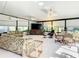 Bright sunroom with wall-to-wall windows, comfortable seating, and ceiling fans at 417 Lake Butler Dr, Kissimmee, FL 34759