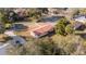 Aerial view showcases a cozy home with a red metal roof, nestled among lush greenery in a quiet neighborhood at 11213 Se 53Rd Ct, Belleview, FL 34420