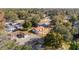 Real estate aerial view of a residential home featuring a red roof and well-kept landscaping in a serene, wooded neighborhood at 11213 Se 53Rd Ct, Belleview, FL 34420