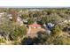 Real estate aerial view of home with a striking red roof, nestled in a community with lush tree coverage at 11213 Se 53Rd Ct, Belleview, FL 34420