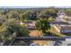 Aerial view of a cozy home with a red metal roof, nestled among mature trees in a quiet residential neighborhood at 11213 Se 53Rd Ct, Belleview, FL 34420