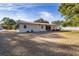 Rear exterior view of the house with a large yard and mature trees at 11213 Se 53Rd Ct, Belleview, FL 34420