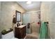 This bathroom features tiled walls, a vanity with a dark wood cabinet, and a walk-in shower at 11213 Se 53Rd Ct, Belleview, FL 34420