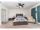 A cozy bedroom with a ceiling fan, a plush armchair, and a patterned comforter on the bed at 812 Brooklet Dr, Davenport, FL 33837