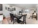 A modern dining table with seating for six, adjacent to the living room and a decorative gallery wall at 812 Brooklet Dr, Davenport, FL 33837