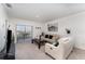 Bright living room featuring neutral carpeting, comfortable seating, and a sliding glass door at 812 Brooklet Dr, Davenport, FL 33837