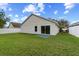 Home featuring a grassy backyard with full fencing, and a sliding door entryway at 536 Cheshire Way, Davenport, FL 33897