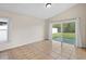 Bright bedroom with ceramic tile floors, large sliding glass door leading to the backyard, and neutral paint at 536 Cheshire Way, Davenport, FL 33897