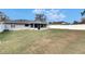 Spacious backyard featuring a green lawn, white fence, and partially screened-in patio at 1060 Colony Park Dr, Lakeland, FL 33813