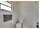 Bright bathroom with a toilet, gray towel, and a window for natural light at 1060 Colony Park Dr, Lakeland, FL 33813