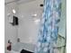 Bathroom with white tile shower, patterned shower curtain, and chrome fixtures at 1060 Colony Park Dr, Lakeland, FL 33813
