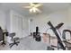 Bright bonus room featuring a treadmill, storage boxes, and a ceiling fan at 1060 Colony Park Dr, Lakeland, FL 33813