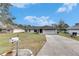 Charming one-story home with a well-manicured lawn and a long driveway under a beautiful sky at 1060 Colony Park Dr, Lakeland, FL 33813