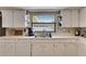 Bright kitchen with white cabinets and stainless steel sink under a window at 1060 Colony Park Dr, Lakeland, FL 33813