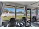 Enclosed patio with ceiling fan, neutral curtains, seating and backyard views at 1060 Colony Park Dr, Lakeland, FL 33813