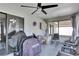 Enclosed patio featuring a ceiling fan, TV, seating and an outdoor view of the yard at 1060 Colony Park Dr, Lakeland, FL 33813