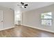 Bright bedroom featuring a ceiling fan, light hardwood floors, and an ensuite bathroom, offering a comfortable living space at 116 Woodlane Ave, Wildwood, FL 34785