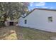 Home exterior featuring white siding, a backyard storage shed, and ample outdoor space at 116 Woodlane Ave, Wildwood, FL 34785