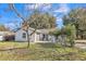 Lovely single-story home features a front-facing garage, a manicured lawn, and mature trees providing natural shade at 116 Woodlane Ave, Wildwood, FL 34785