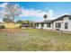 Wide shot of the backyard showcasing a sunroom, fenced perimeter, well-maintained lawn, and exterior of the home at 610 Moonpenny Cir, Port Orange, FL 32127